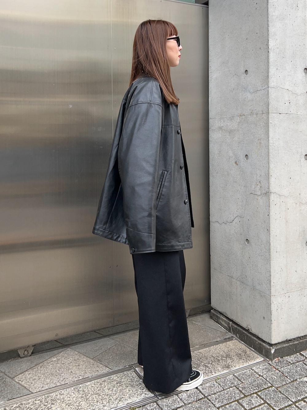 ブラック系のその他アウター、ホワイト系のTシャツ/カットソー、ブラック系のニット/セーターを着用したレディースの冬コーディネートの3枚目の写真