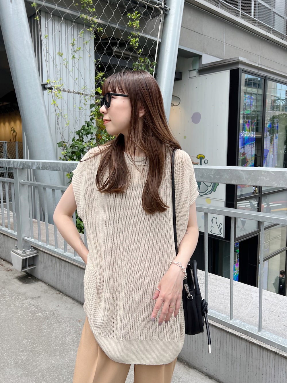 ベージュ系のトップス、ベージュ系のスラックス、ベージュ系のサンダルを着用したレディースの夏コーディネートの3枚目の写真