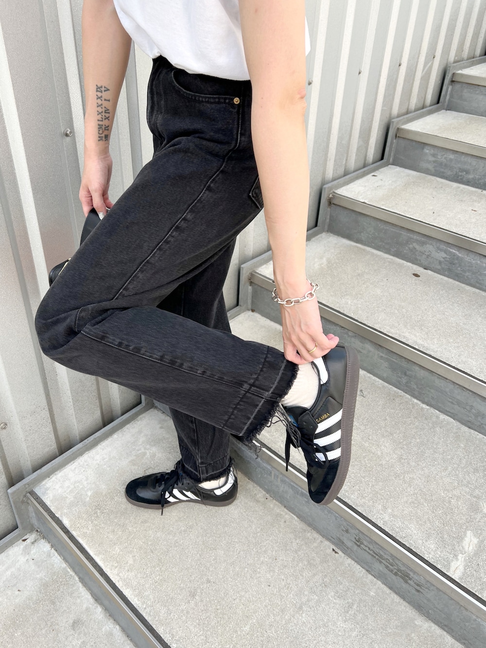 ホワイト系のTシャツ/カットソー、その他のハンドバッグ、ブラック系のデニムパンツを着用したレディースの秋コーディネートの5枚目の写真