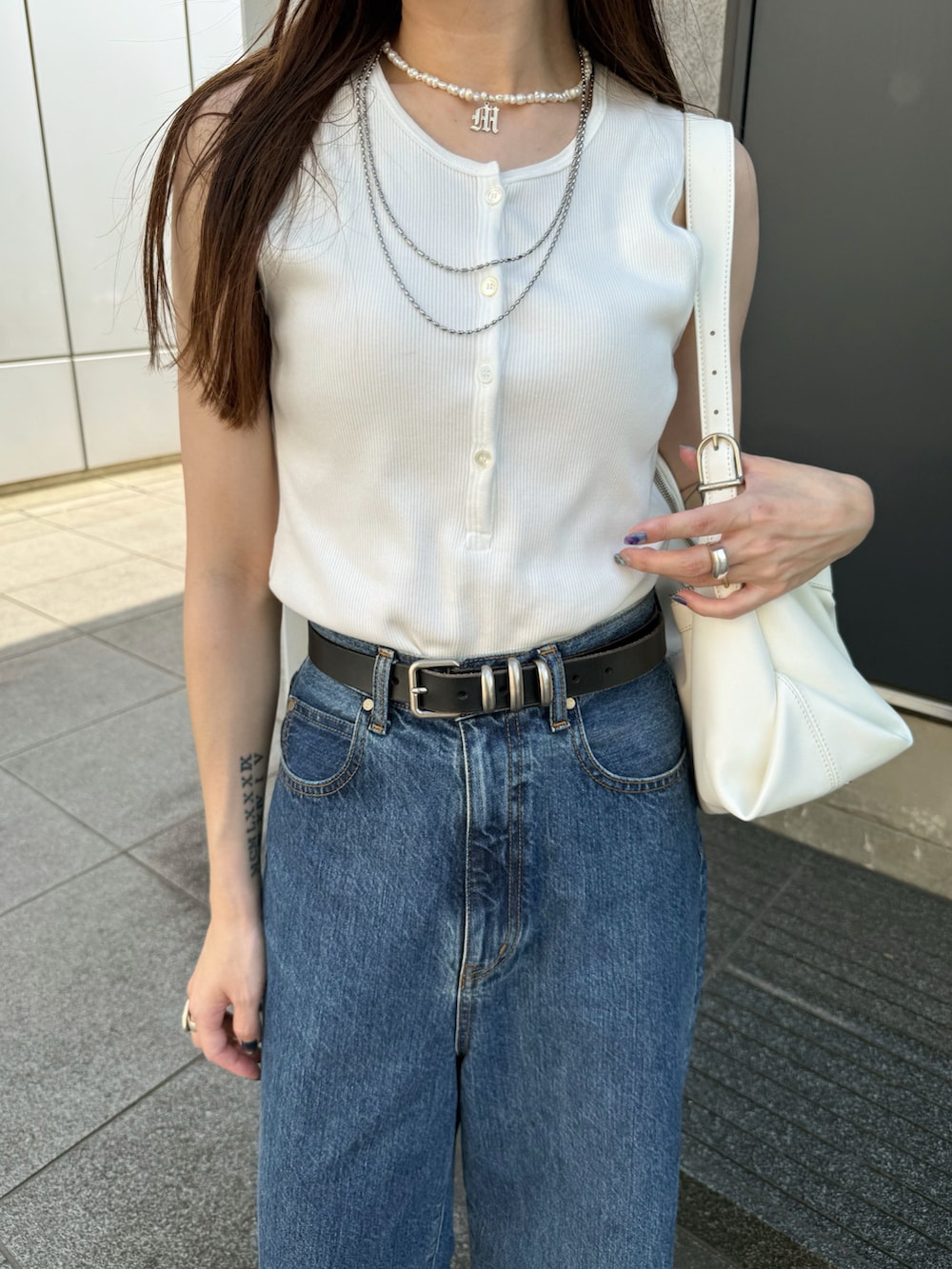 ホワイト系のタンクトップ、ブルー系のデニムパンツ、ホワイト系のスニーカーを着用したレディースの夏コーディネートの5枚目の写真