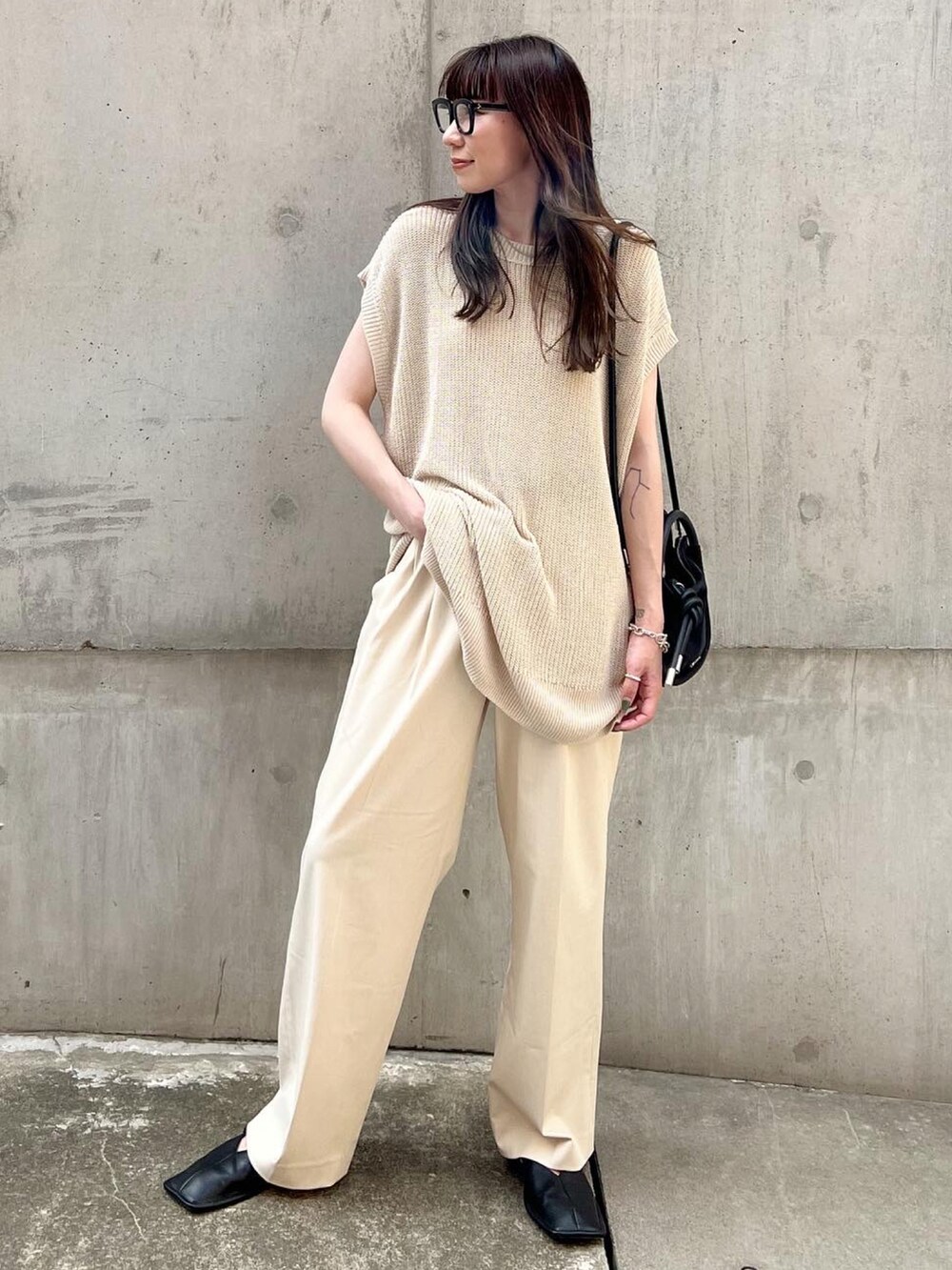 ホワイト系のパンツ、ブラック系のスリッポン、ベージュ系のトップスを着用したレディースの夏コーディネートの2枚目の写真