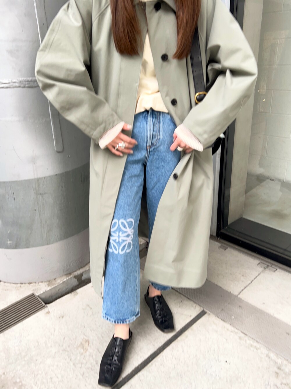 グリーン系のステンカラーコート、ホワイト系のTシャツ/カットソー、ブルー系のデニムパンツを着用したレディースの春コーディネートの5枚目の写真