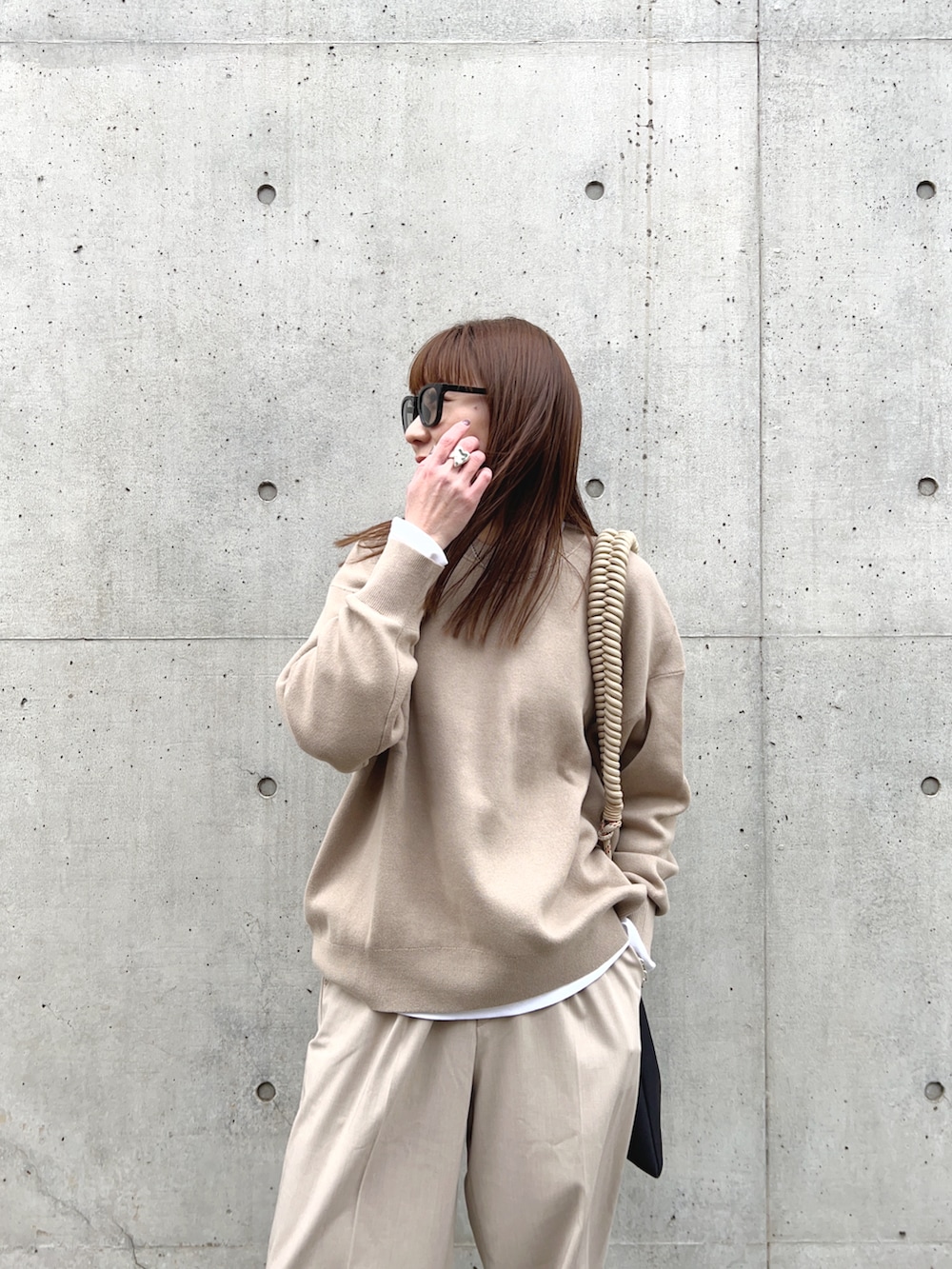 ベージュ系のトップス、ベージュ系のパンツ、ベージュ系のショルダーバッグを着用したレディースの冬コーディネートの4枚目の写真