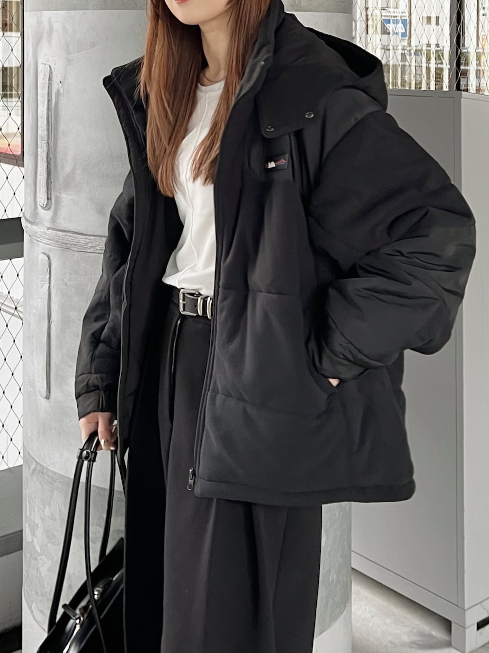ブラック系のブルゾン、ブラック系のその他パンツ、ホワイト系のTシャツ/カットソーを着用したレディースの冬コーディネートの4枚目の写真