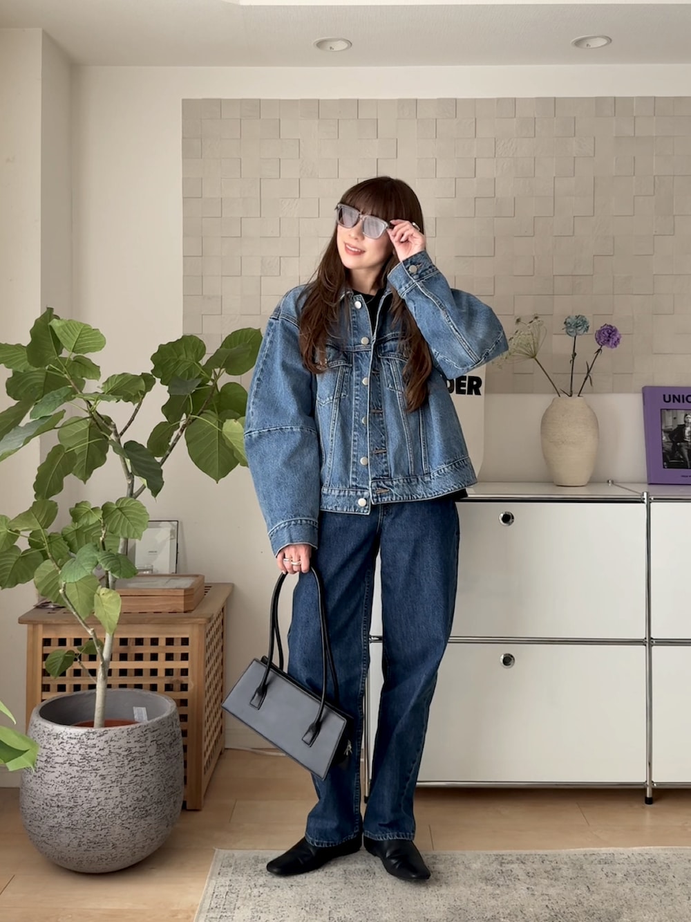 ブルー系のデニムジャケット、ブラック系のTシャツ/カットソー、ブルー系のデニムパンツを着用したレディースの春コーディネートの3枚目の写真