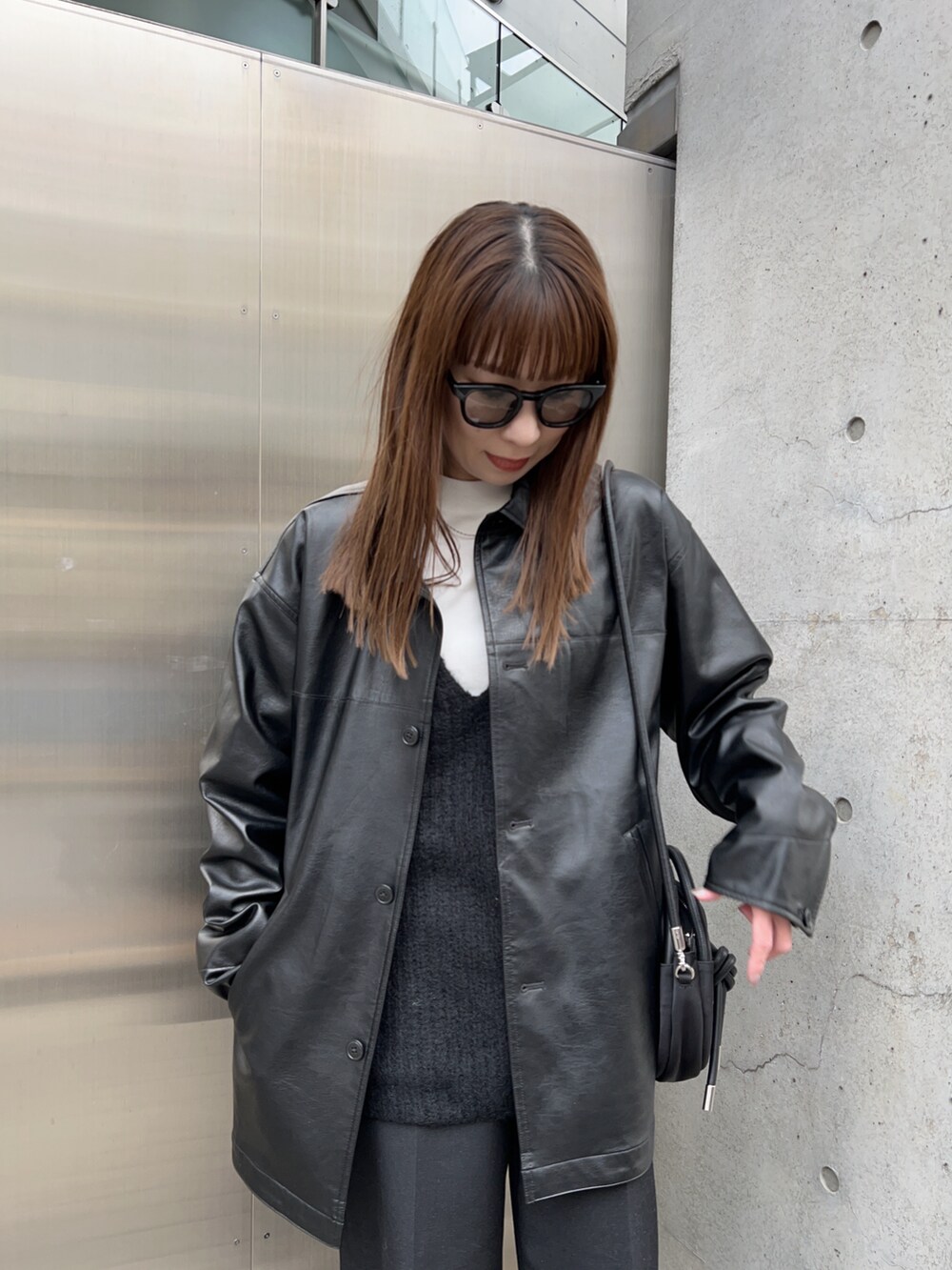 ブラック系のその他アウター、ホワイト系のTシャツ/カットソー、ブラック系のニット/セーターを着用したレディースの冬コーディネートの4枚目の写真