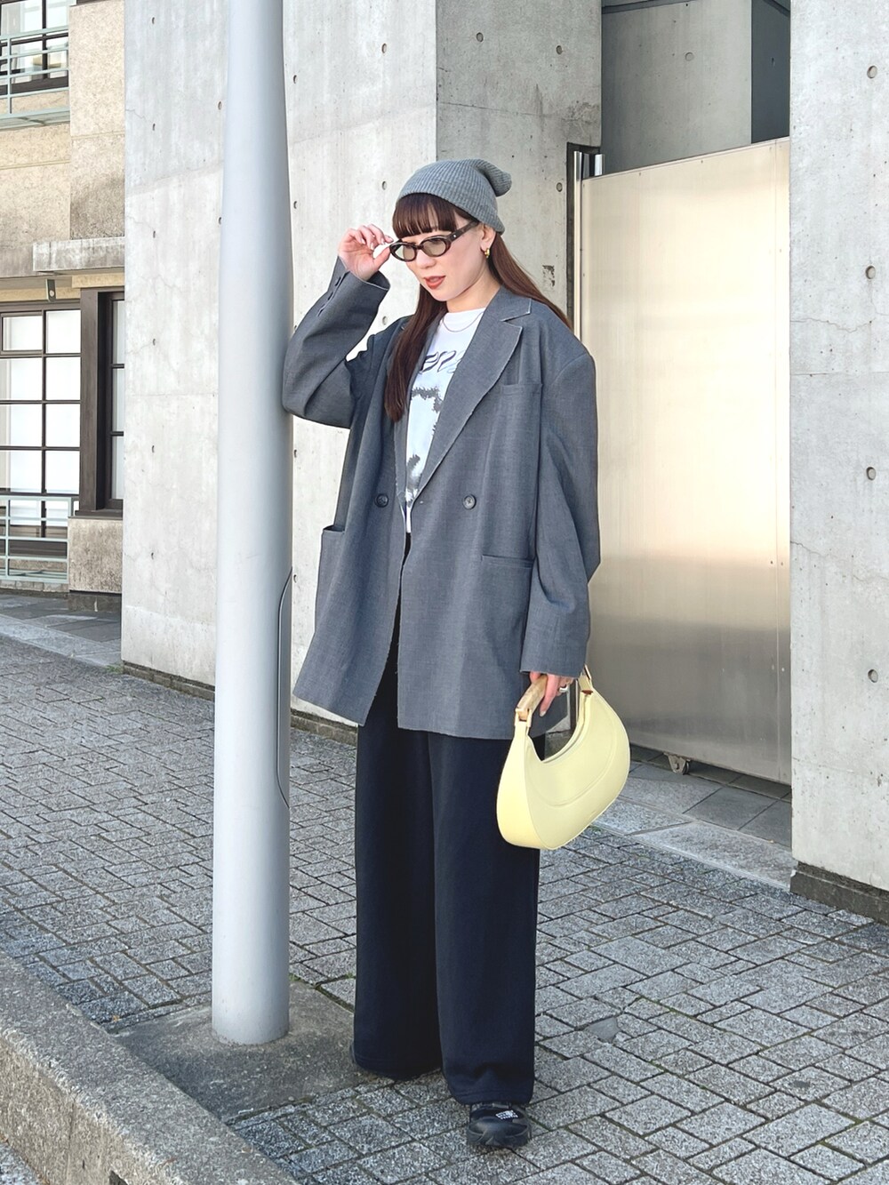 グレー系のテーラードジャケット、ホワイト系のTシャツ/カットソー、イエロー系のハンドバッグを着用したレディースの春コーディネートの2枚目の写真