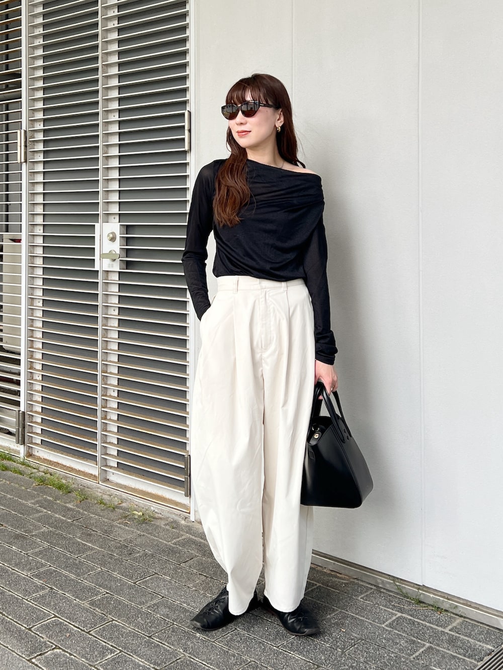 ブラック系のTシャツ/カットソー、ホワイト系のその他パンツ、ブラック系のバッグを着用したレディースの春コーディネートの3枚目の写真