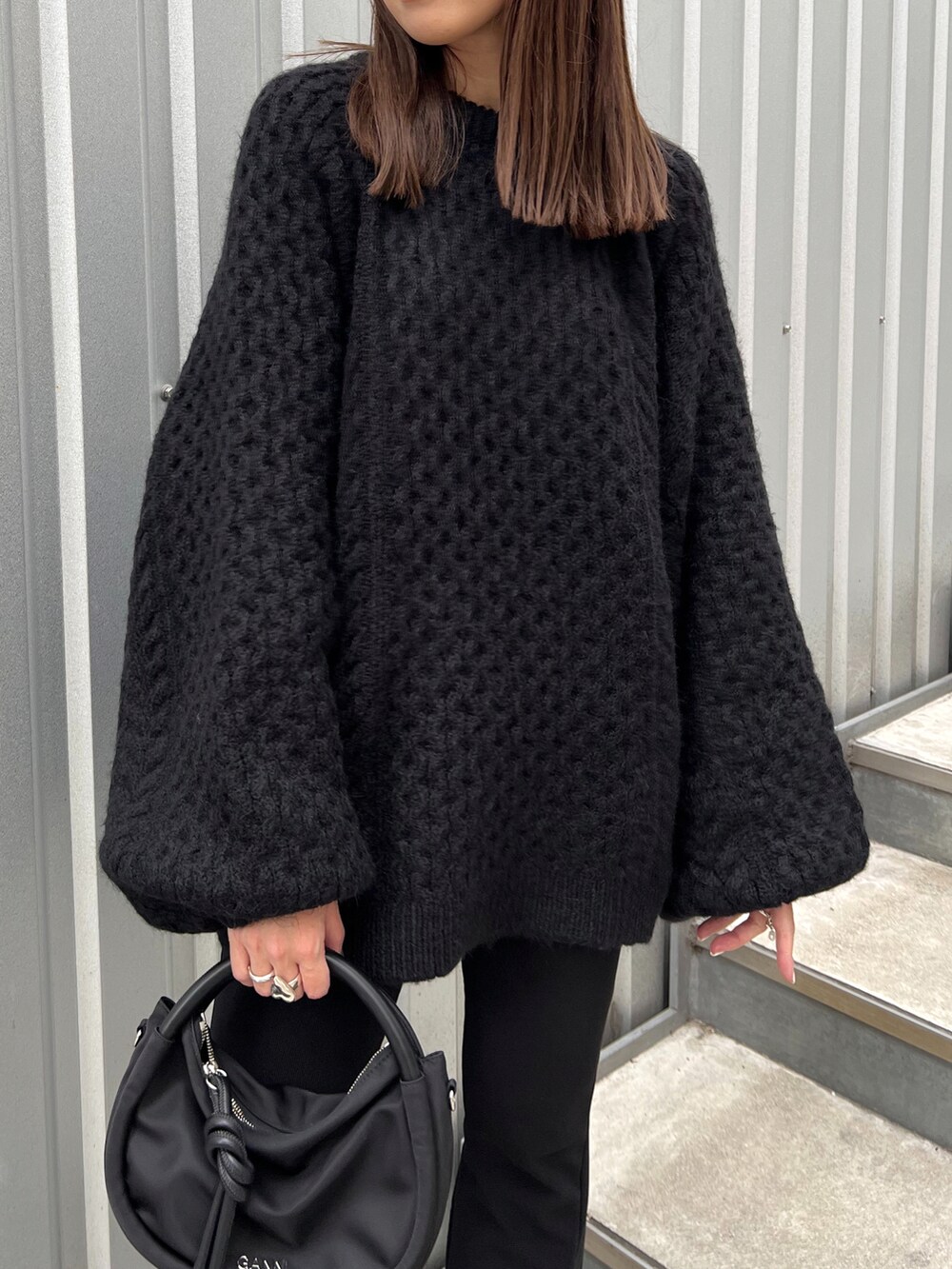 ブラック系のニット/セーター、ブラック系のショルダーバッグ、ブラック系のシューズを着用したレディースの秋コーディネートの4枚目の写真