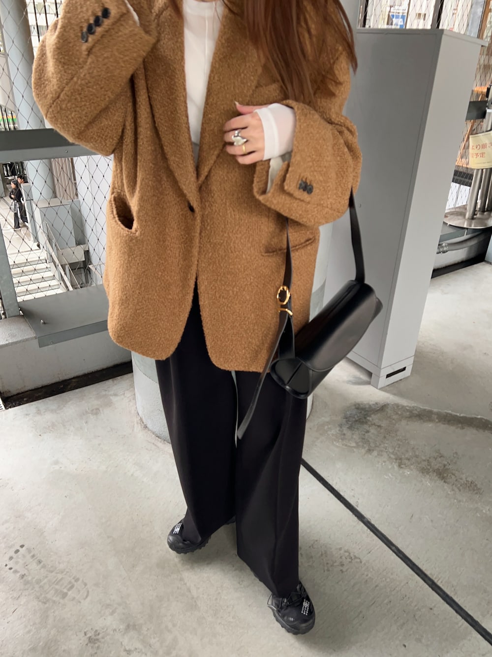ブラウン系のジャケット/アウター、ホワイト系のTシャツ/カットソー、ブラック系のその他パンツを着用したレディースの冬コーディネートの4枚目の写真