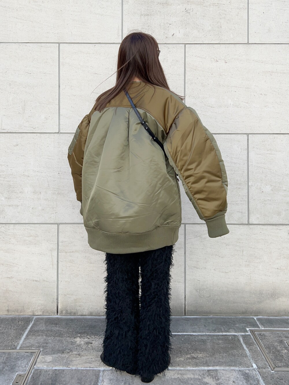 グリーン系のブルゾン、ブラック系のショルダーバッグ、ブラック系のその他パンツを着用したレディースの冬コーディネートの3枚目の写真