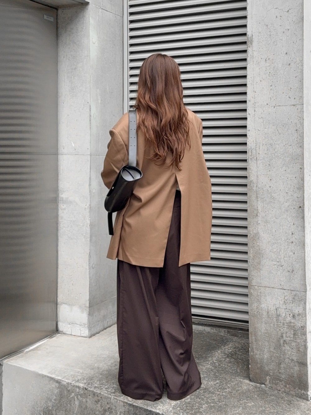 ブラウン系のその他アウター、ブラウン系のその他パンツ、ホワイト系のTシャツ/カットソーを着用したレディースの秋コーディネートの3枚目の写真