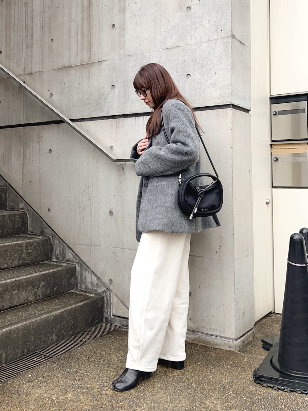 グレー系のテーラードジャケット、ホワイト系のスウェットパンツ、ブラック系のショルダーバッグを着用したレディースの冬コーディネートの3枚目の写真