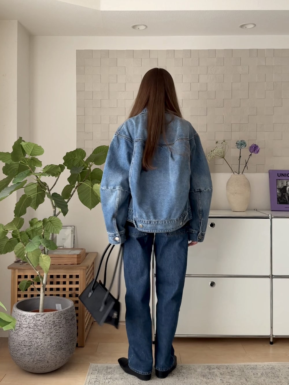 ブルー系のデニムジャケット、ブラック系のTシャツ/カットソー、ブルー系のデニムパンツを着用したレディースの春コーディネートの5枚目の写真