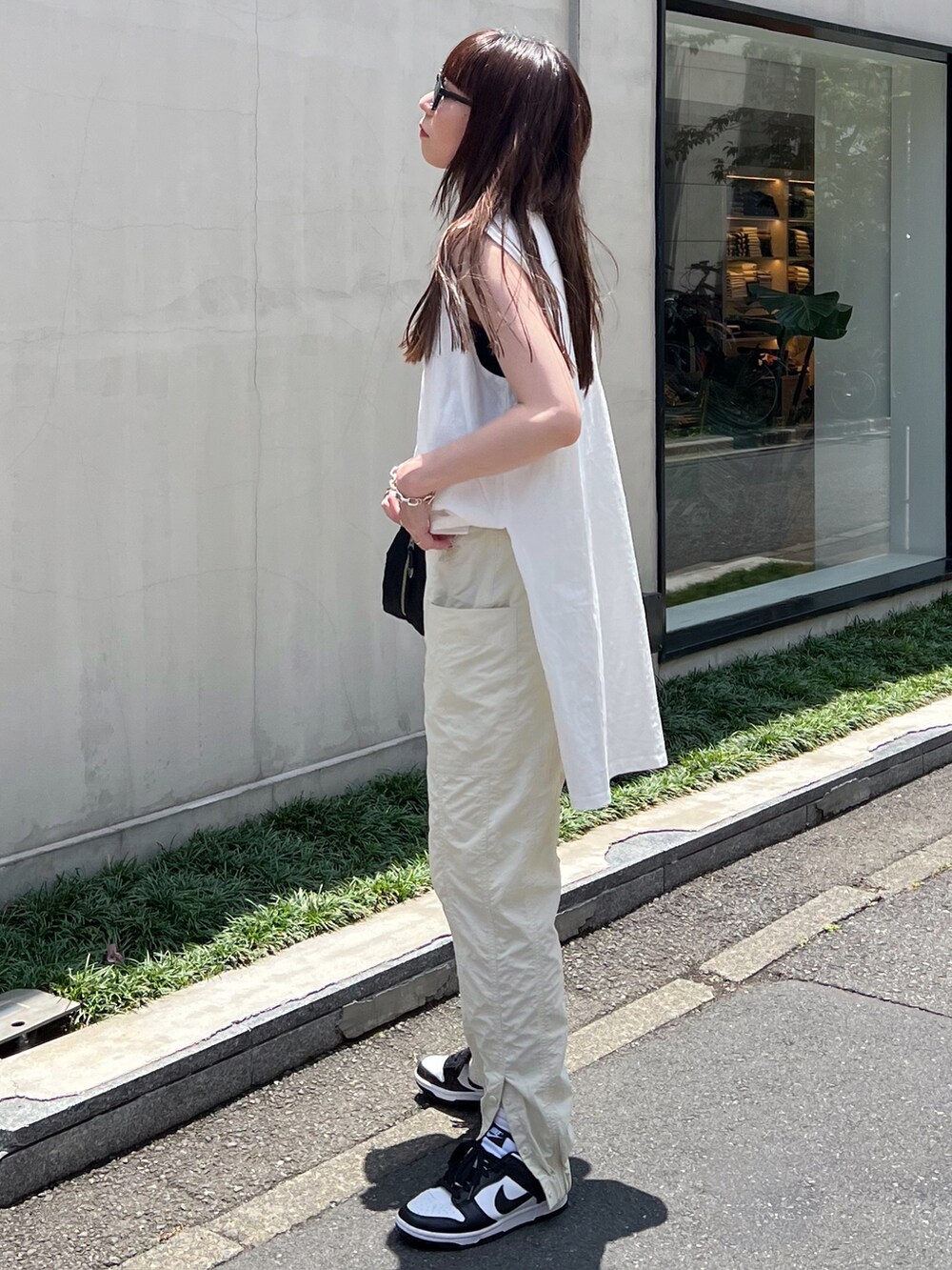 ホワイト系のTシャツ/カットソー、ホワイト系のその他パンツ、ブラック系のショルダーバッグを着用したレディースの夏コーディネートの2枚目の写真