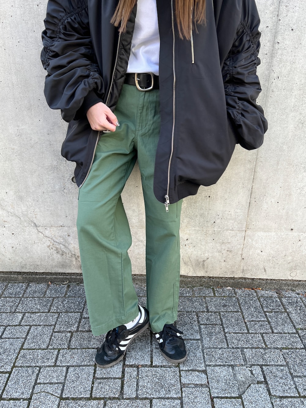 ブラック系のMA-1、ブラック系のハンドバッグ、ホワイト系のTシャツ/カットソーを着用したレディースの冬コーディネートの5枚目の写真