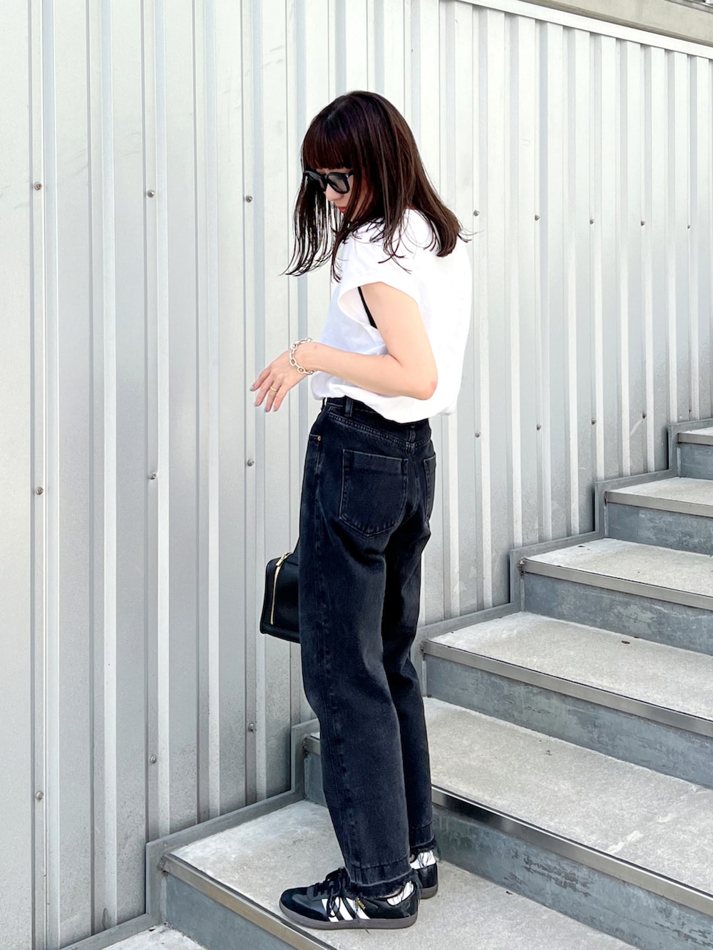 ホワイト系のTシャツ/カットソー、その他のハンドバッグ、ブラック系のデニムパンツを着用したレディースの秋コーディネートの2枚目の写真