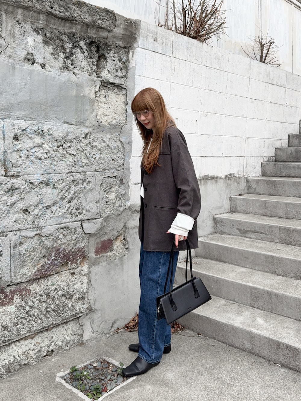 ホワイト系のTシャツ/カットソー、ブラック系のスリッポン、グレー系のジャケット/アウターを着用したレディースの春コーディネートの2枚目の写真