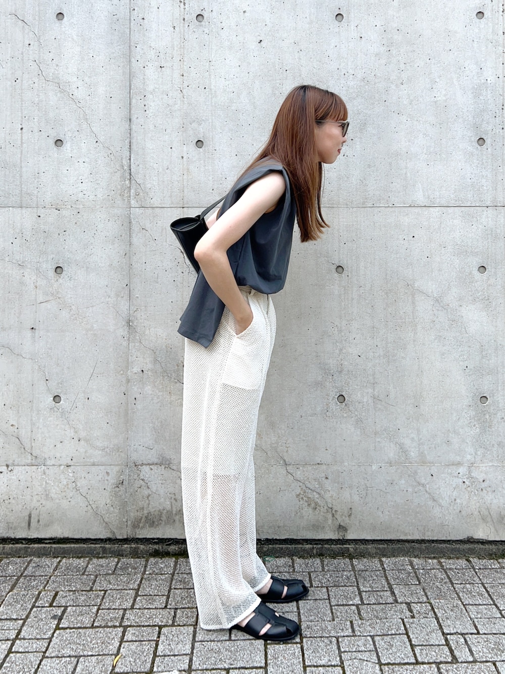 グレー系のタンクトップ、ホワイト系のその他パンツ、ブラック系のショルダーバッグを着用したレディースの夏コーディネートの3枚目の写真