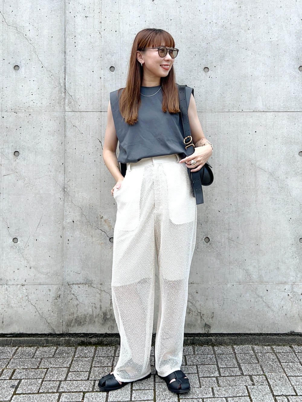 グレー系のタンクトップ、ホワイト系のその他パンツ、ブラック系のショルダーバッグを着用したレディースの夏コーディネートの2枚目の写真