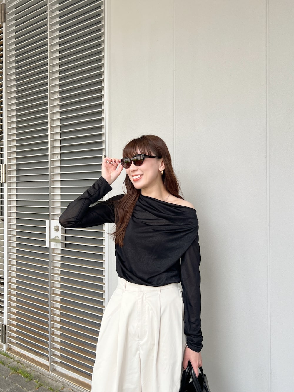 ブラック系のTシャツ/カットソー、ホワイト系のその他パンツ、ブラック系のバッグを着用したレディースの春コーディネートの5枚目の写真