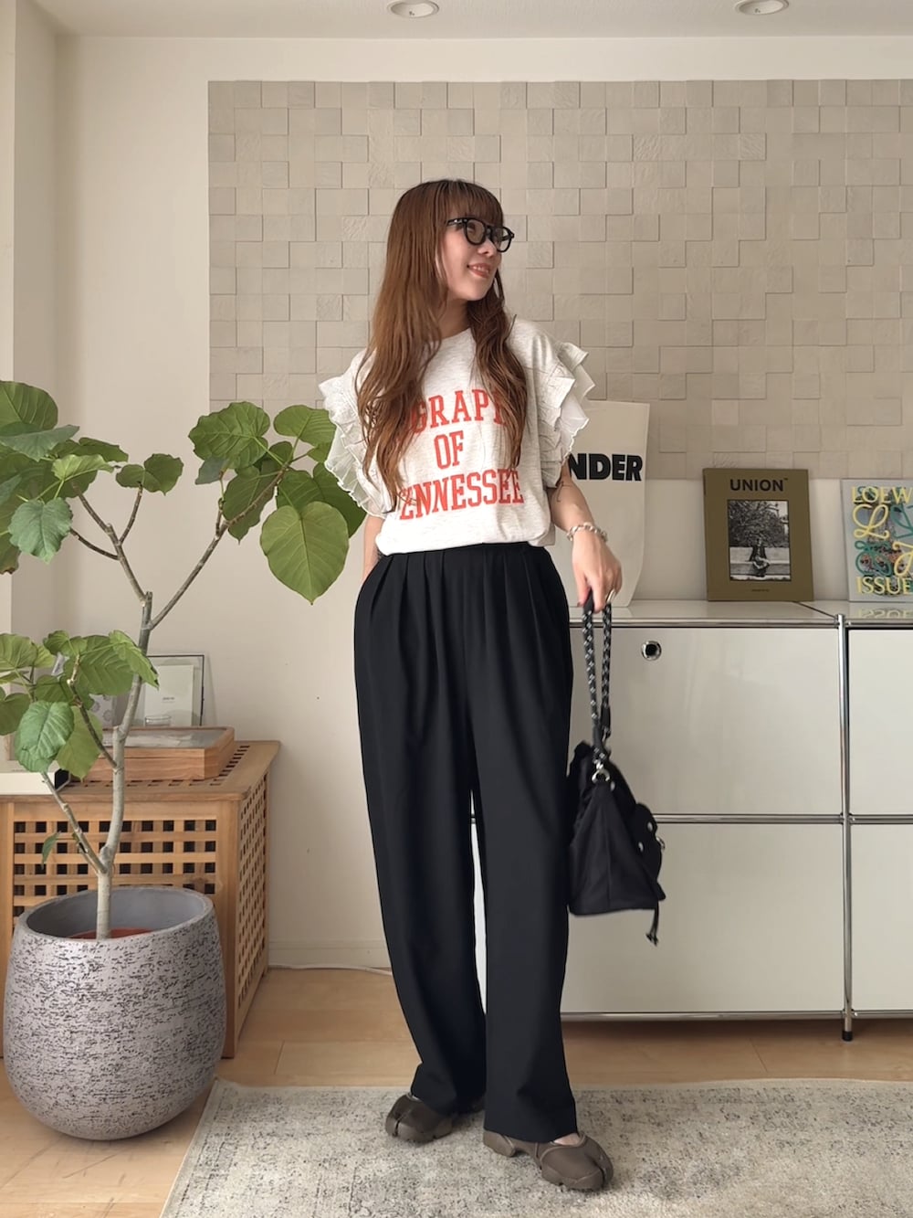 ベージュ系のTシャツ/カットソー、ブラック系のスラックス、ブラック系のショルダーバッグを着用したレディースの夏コーディネートの2枚目の写真