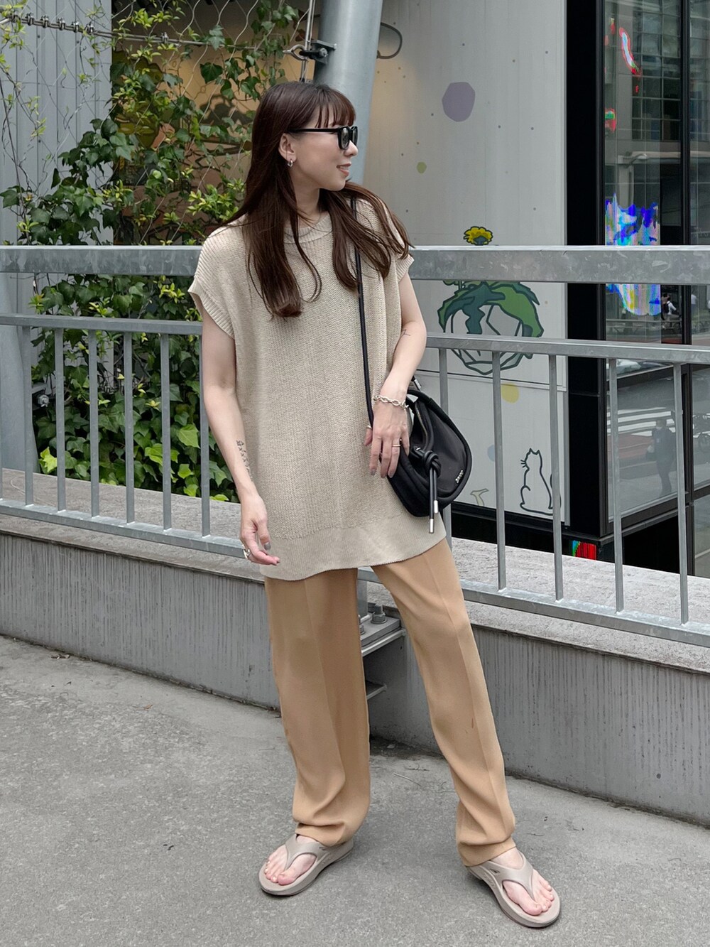 ベージュ系のトップス、ベージュ系のスラックス、ベージュ系のサンダルを着用したレディースの夏コーディネートの2枚目の写真