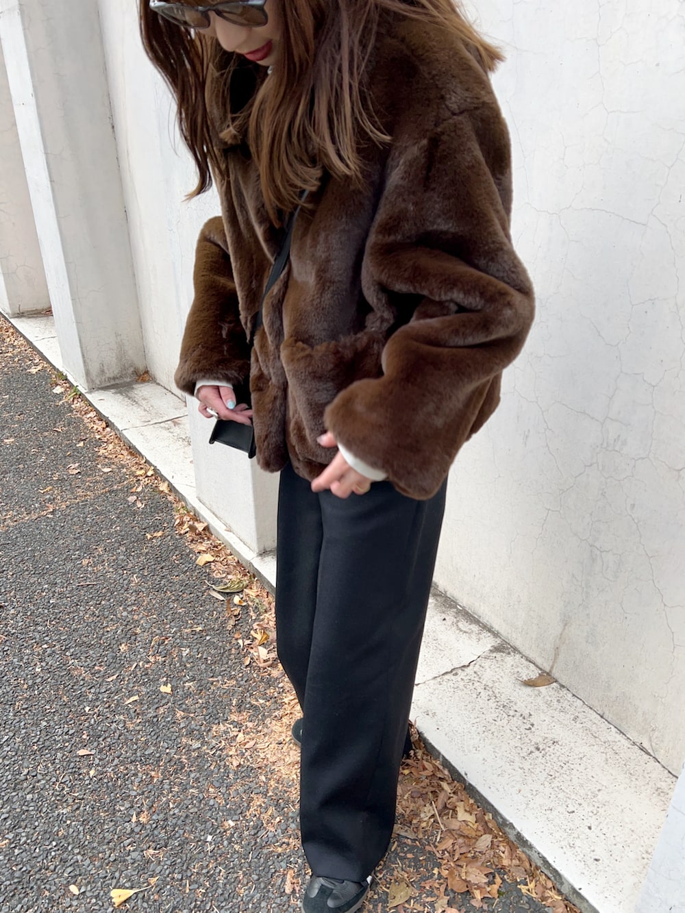 ブラウン系のブルゾン、ブラック系のショルダーバッグ、ホワイト系のTシャツ/カットソーを着用したレディースの冬コーディネートの4枚目の写真