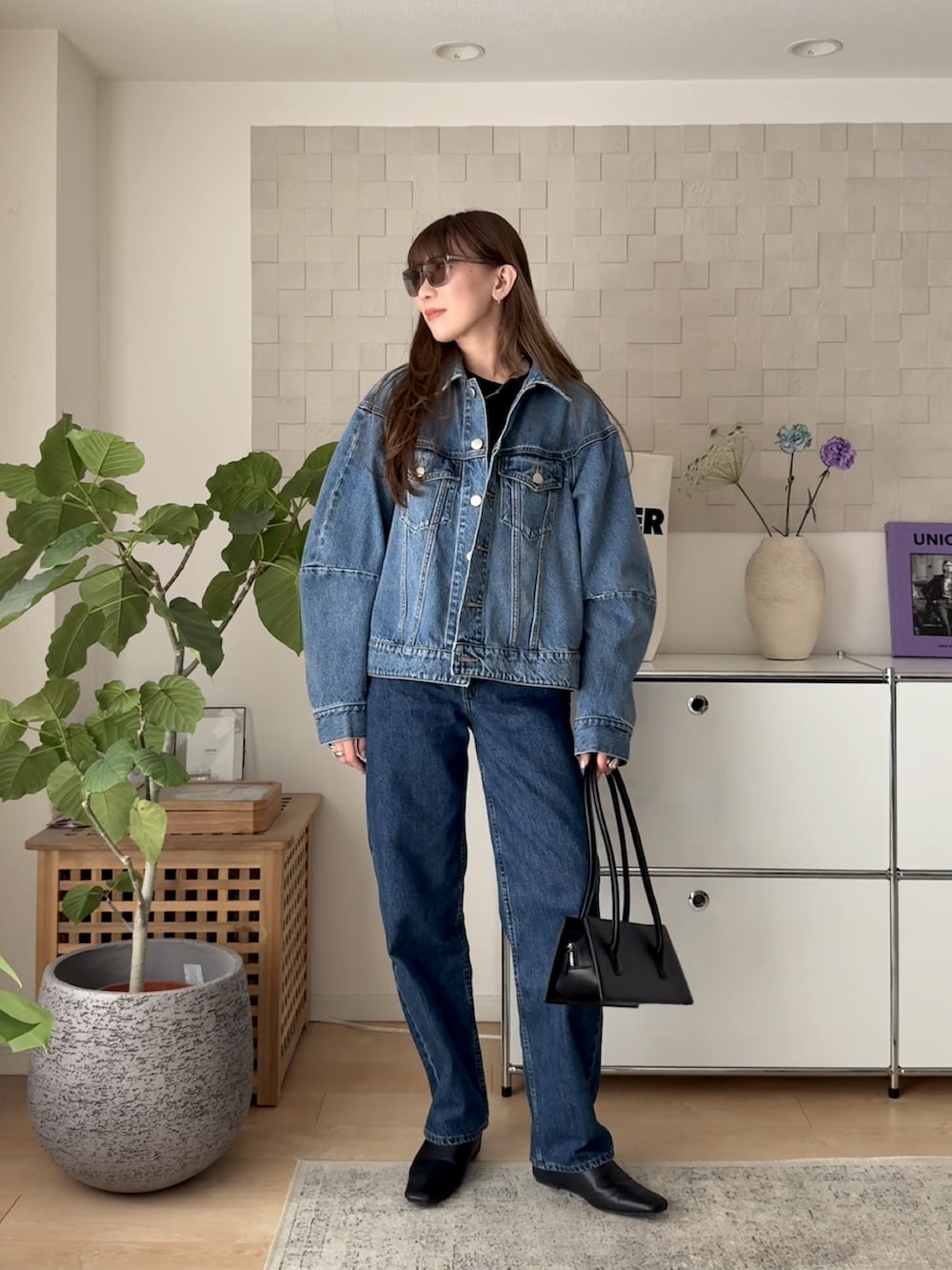 ブルー系のデニムジャケット、ブラック系のTシャツ/カットソー、ブルー系のデニムパンツを着用したレディースの春コーディネートの2枚目の写真