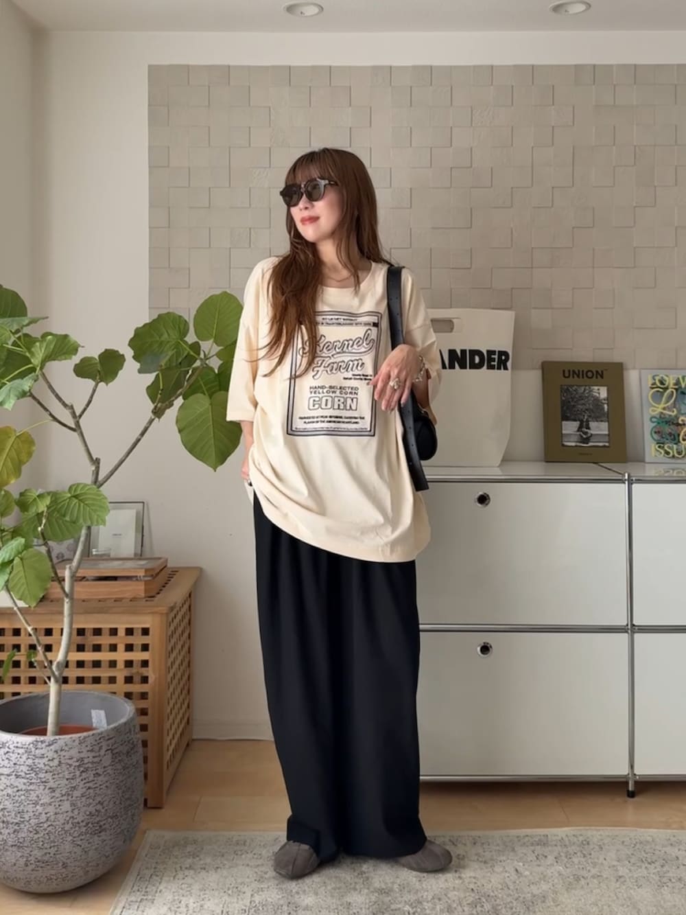 ホワイト系のTシャツ/カットソー、ブラック系のスラックス、ブラック系のショルダーバッグを着用したレディースの夏コーディネートの2枚目の写真
