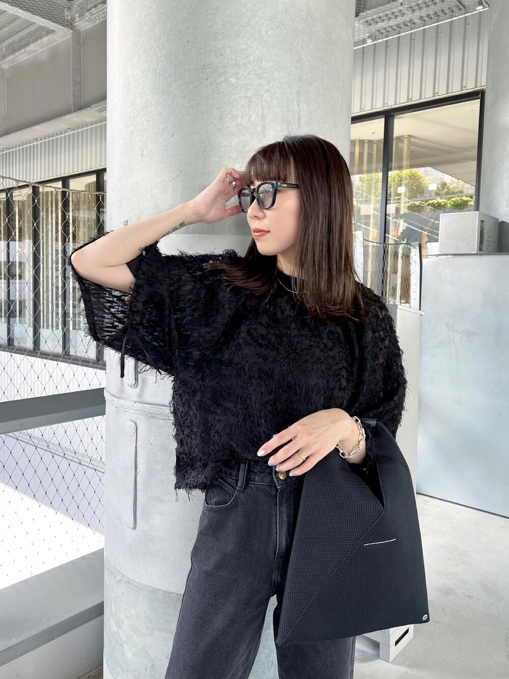 ブラック系のシャツ/ブラウス、ブラック系のデニムパンツ、ブラック系のトートバッグを着用したレディースの秋コーディネートの4枚目の写真