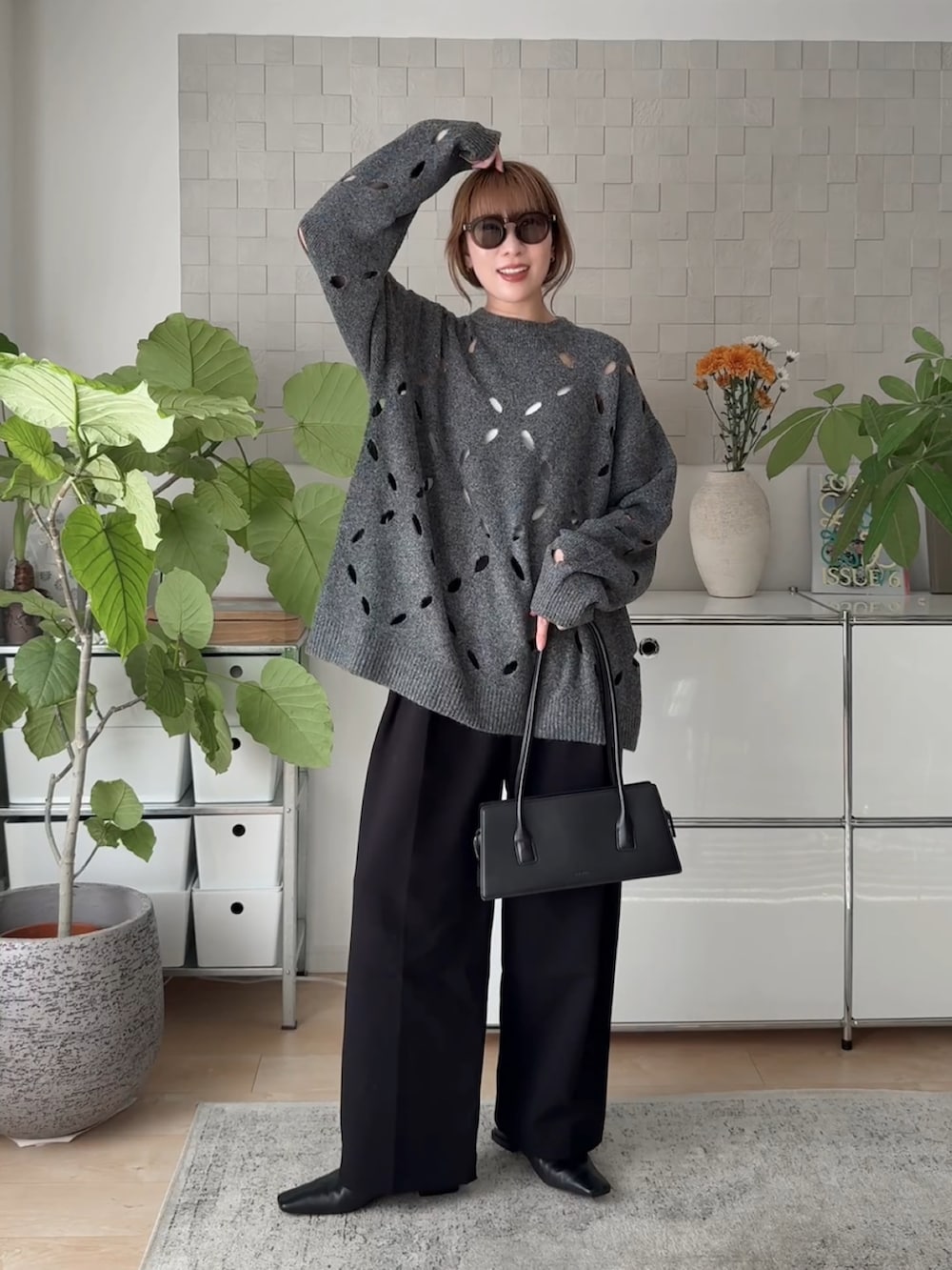 グレー系のニット/セーター、ブラック系のその他パンツ、ブラック系のサンダルを着用したレディースの秋コーディネートの2枚目の写真