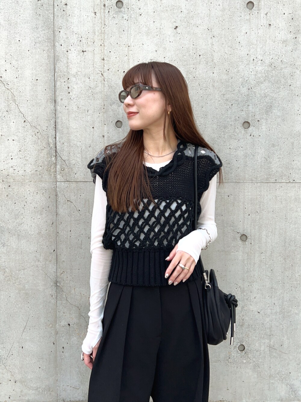 ブラック系のベスト、ホワイト系のTシャツ/カットソー、ブラック系のその他パンツを着用したレディースの春コーディネートの3枚目の写真