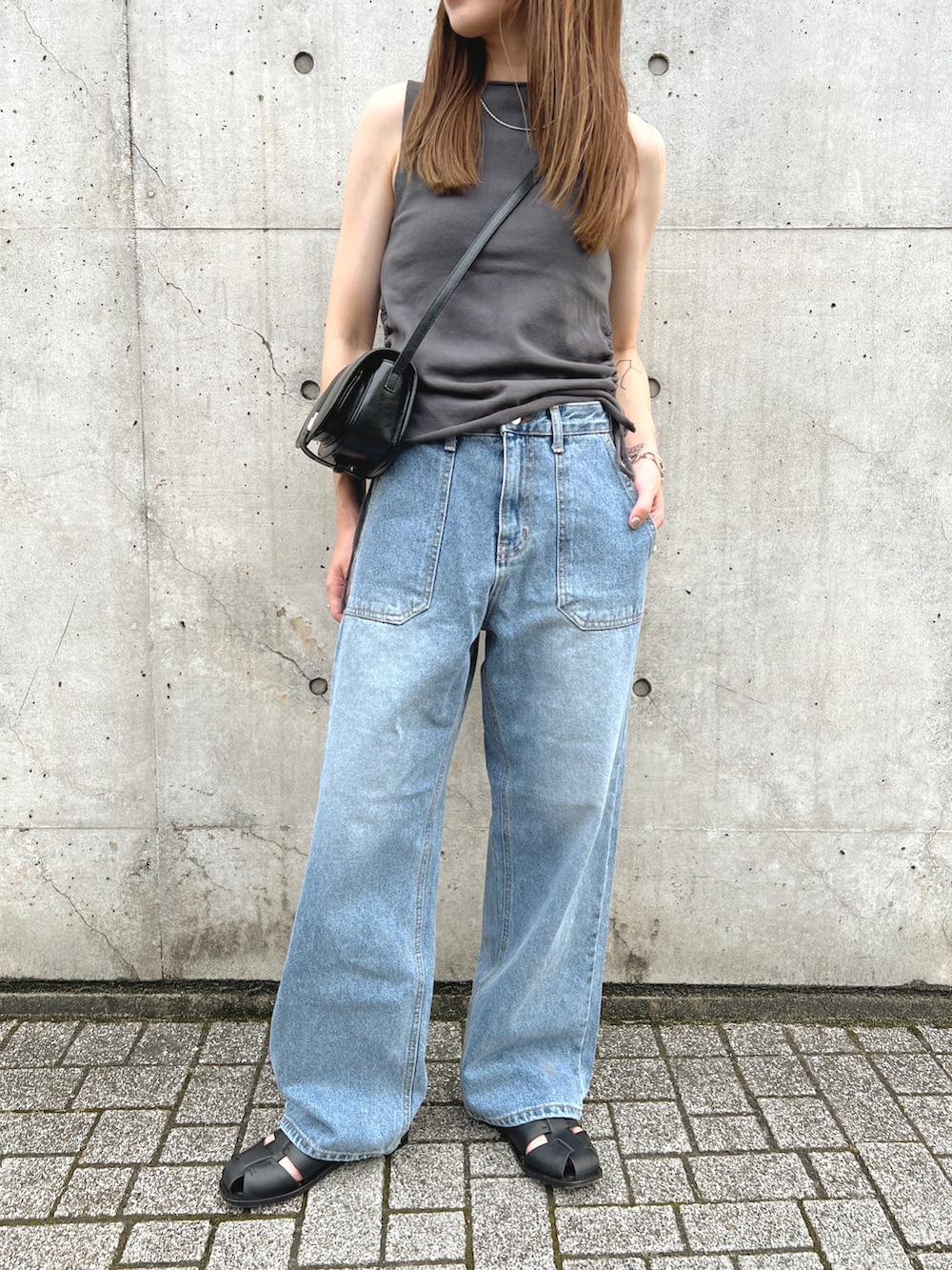 ブラック系のサンダル、グレー系のトップス、ブルー系のデニムパンツを着用したレディースの夏コーディネートの5枚目の写真