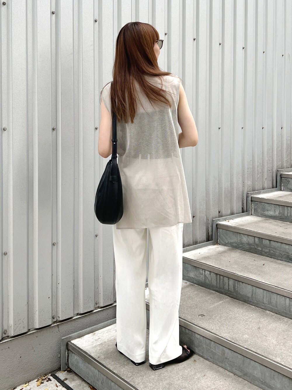 グレー系のTシャツ/カットソー、ブラック系のサンダル、ホワイト系のパンツを着用したレディースの夏コーディネートの4枚目の写真