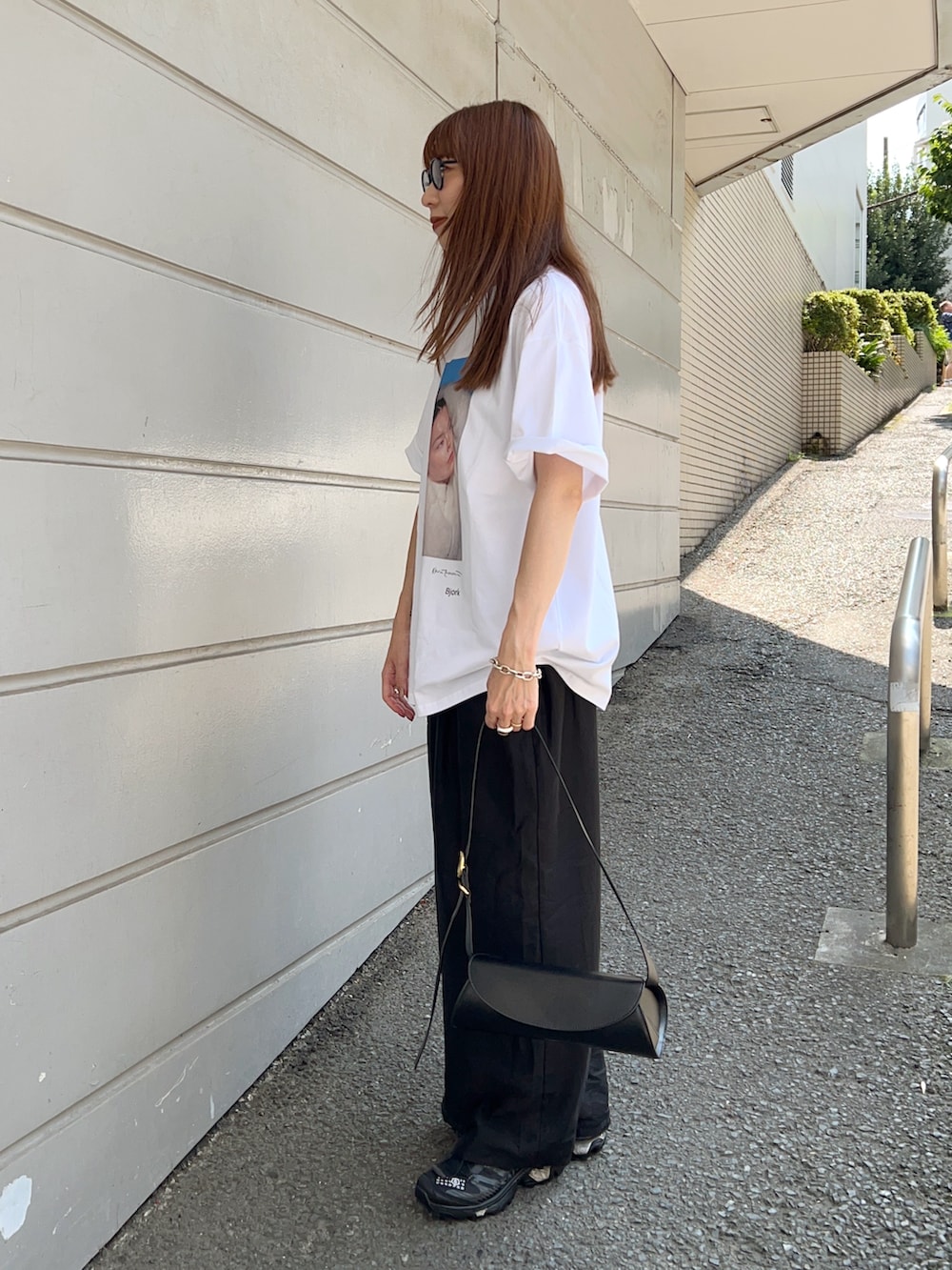 ホワイト系のTシャツ/カットソー、ブラック系のパンツ、ブラック系のショルダーバッグを着用したレディースの夏コーディネートの5枚目の写真