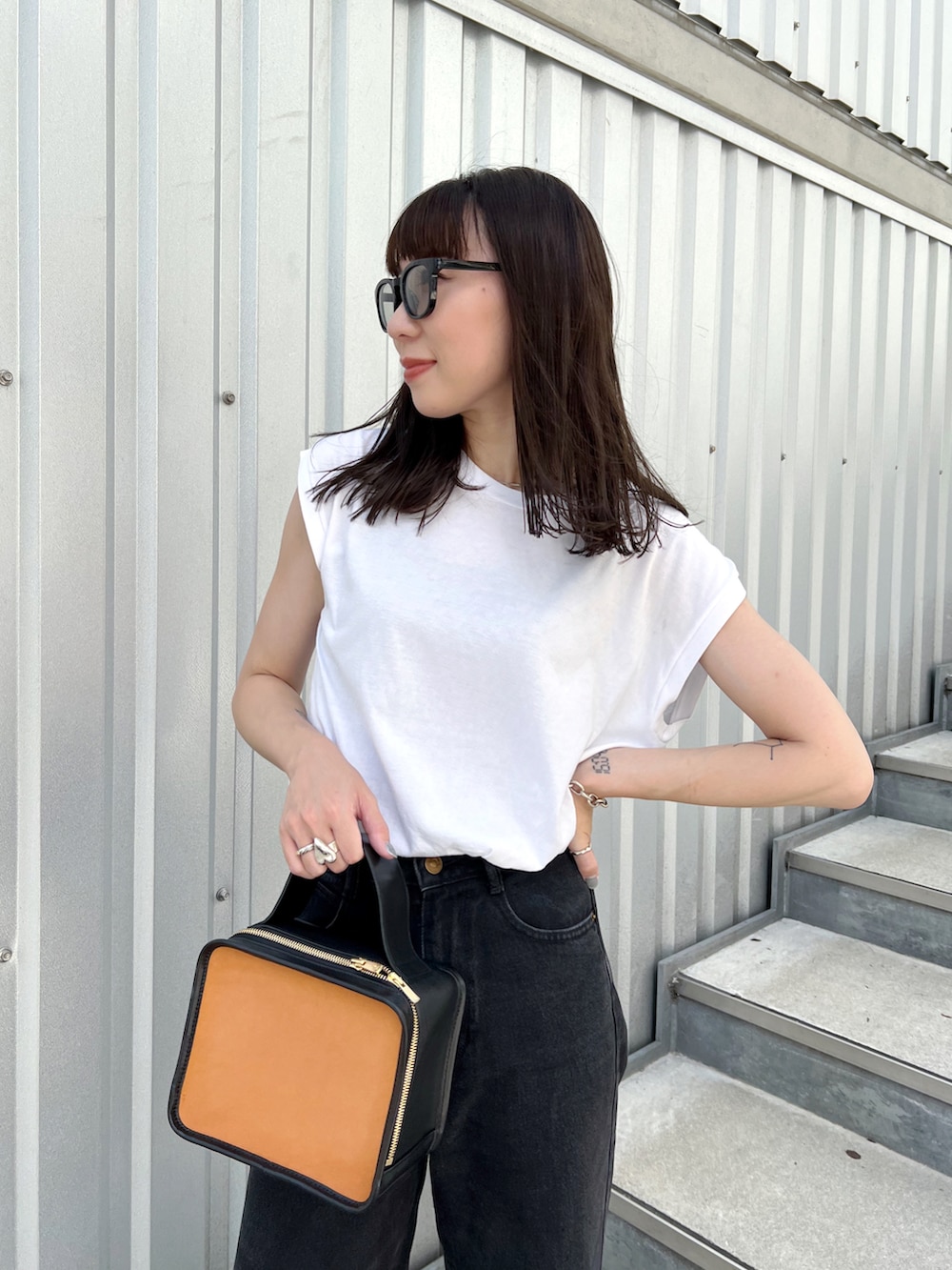 ホワイト系のTシャツ/カットソー、その他のハンドバッグ、ブラック系のデニムパンツを着用したレディースの秋コーディネートの4枚目の写真