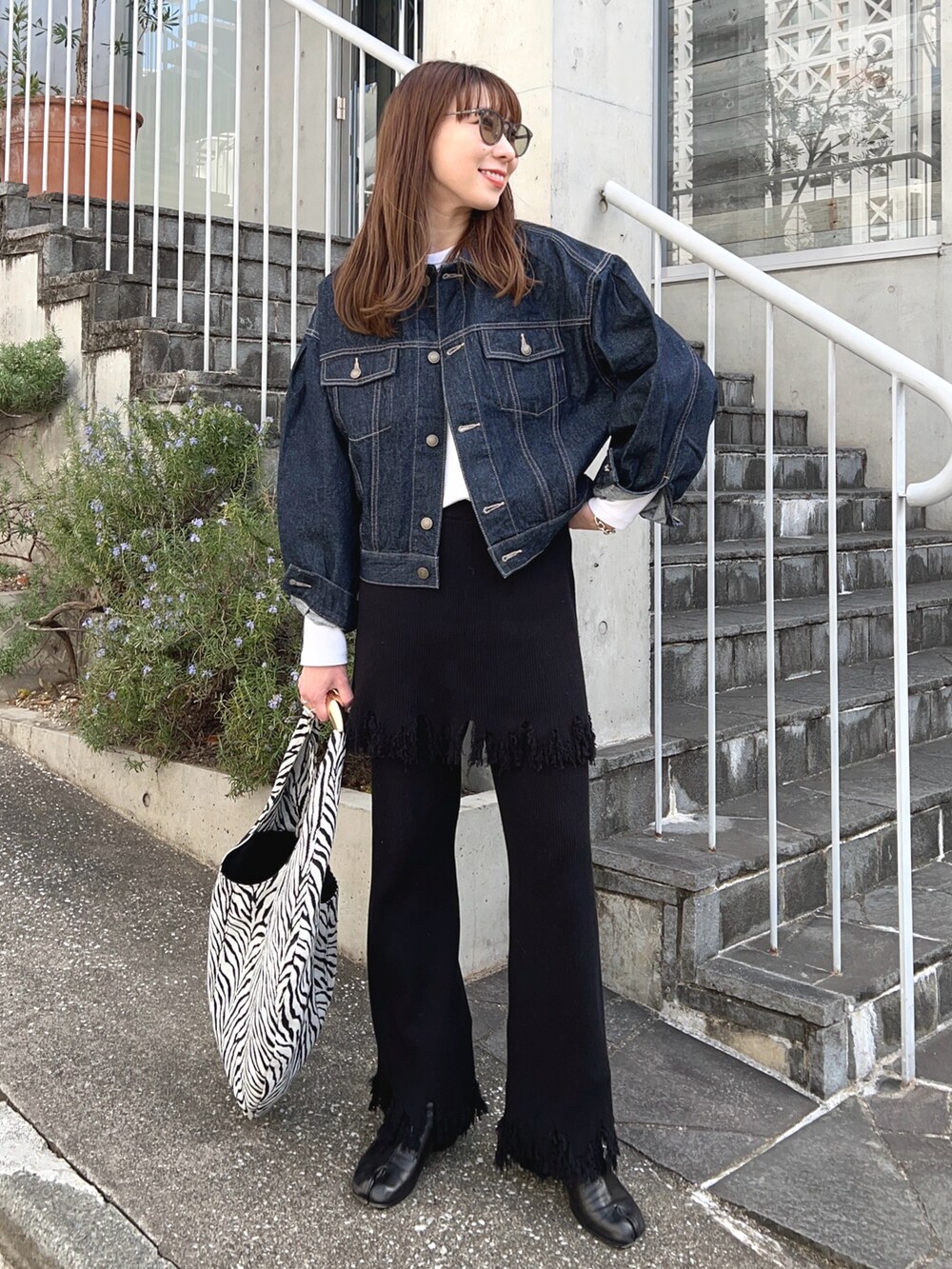 ブルー系のデニムジャケット、ホワイト系のTシャツ/カットソー、その他のトートバッグを着用したレディースの冬コーディネートの2枚目の写真