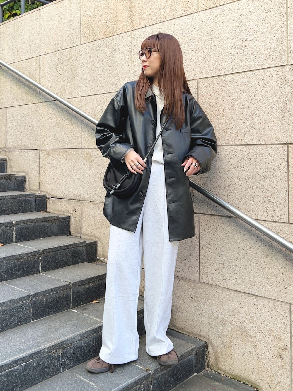 ブラック系のその他アウター、ベージュ系のスウェットパンツ、ホワイト系のTシャツ/カットソーを着用したレディースの秋コーディネートの2枚目の写真