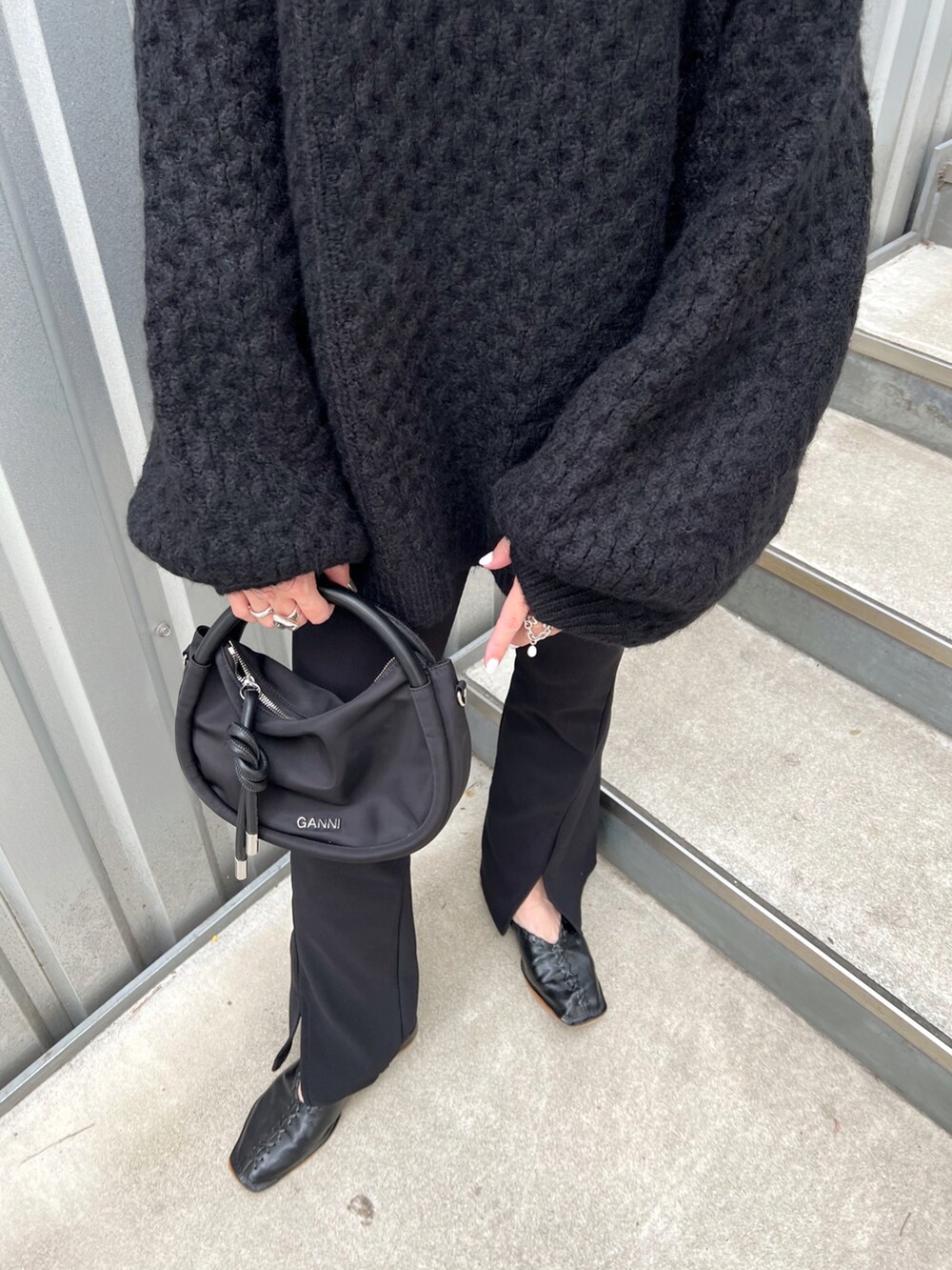 ブラック系のニット/セーター、ブラック系のショルダーバッグ、ブラック系のシューズを着用したレディースの秋コーディネートの5枚目の写真