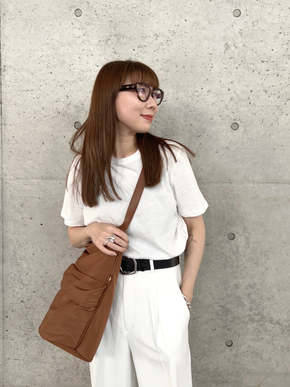 ホワイト系のTシャツ/カットソー、ブラック系のスリッポン、ホワイト系のパンツを着用したレディースの春コーディネートの3枚目の写真