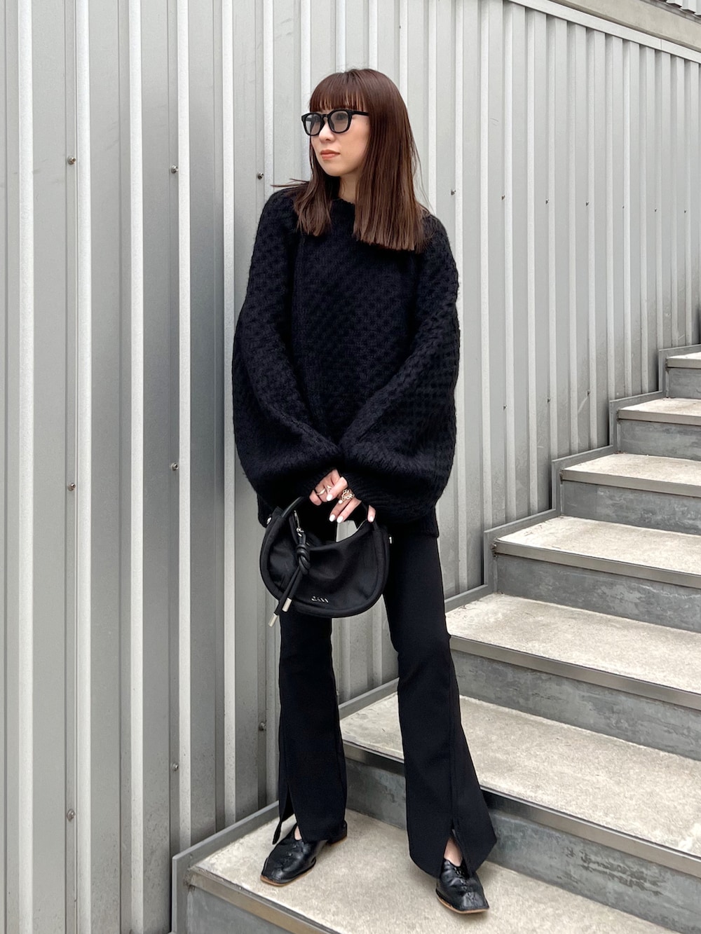 ブラック系のニット/セーター、ブラック系のショルダーバッグ、ブラック系のシューズを着用したレディースの秋コーディネートの2枚目の写真
