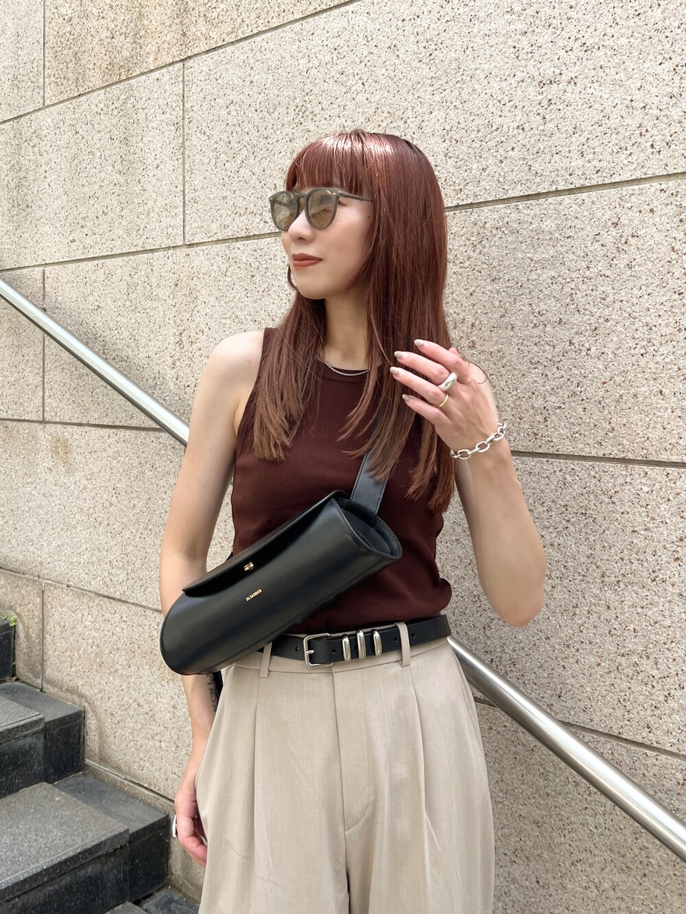 ブラウン系のタンクトップ、ベージュ系のパンツ、ブラック系のショルダーバッグを着用したレディースの夏コーディネートの4枚目の写真