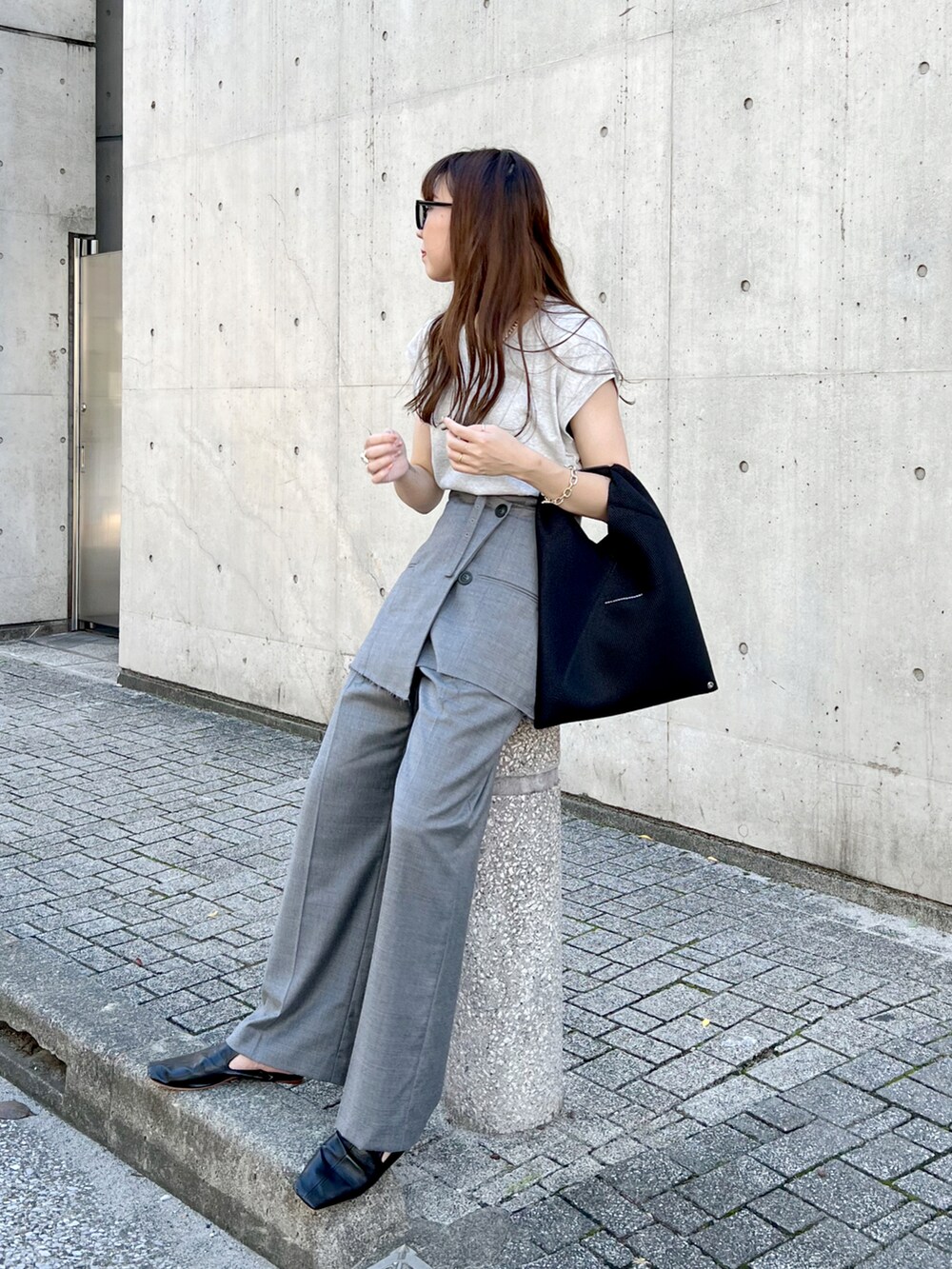 グレー系のTシャツ/カットソー、グレー系のスラックス、ブラック系のトートバッグを着用したレディースの秋コーディネートの3枚目の写真