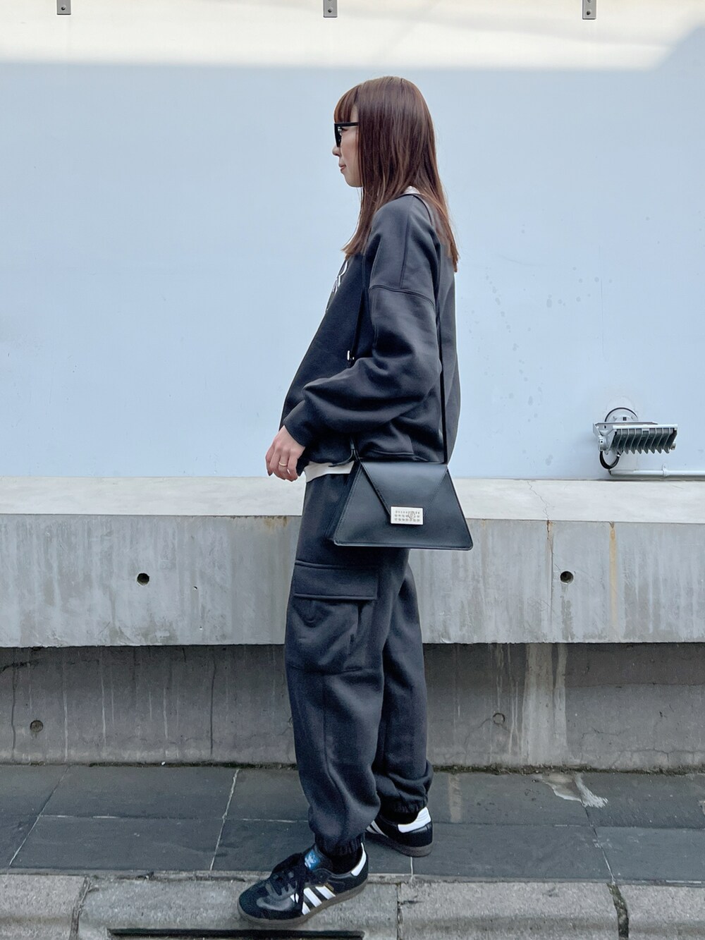 ブラック系のショルダーバッグ、グレー系のスウェット、グレー系のカーゴパンツを着用したレディースの冬コーディネートの3枚目の写真