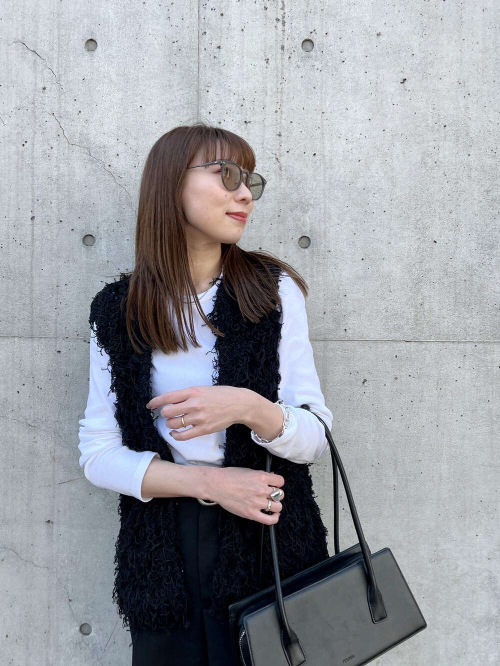 ブラック系のベスト、グレー系のその他パンツ、ブラック系のブーツを着用したレディースの春コーディネートの4枚目の写真