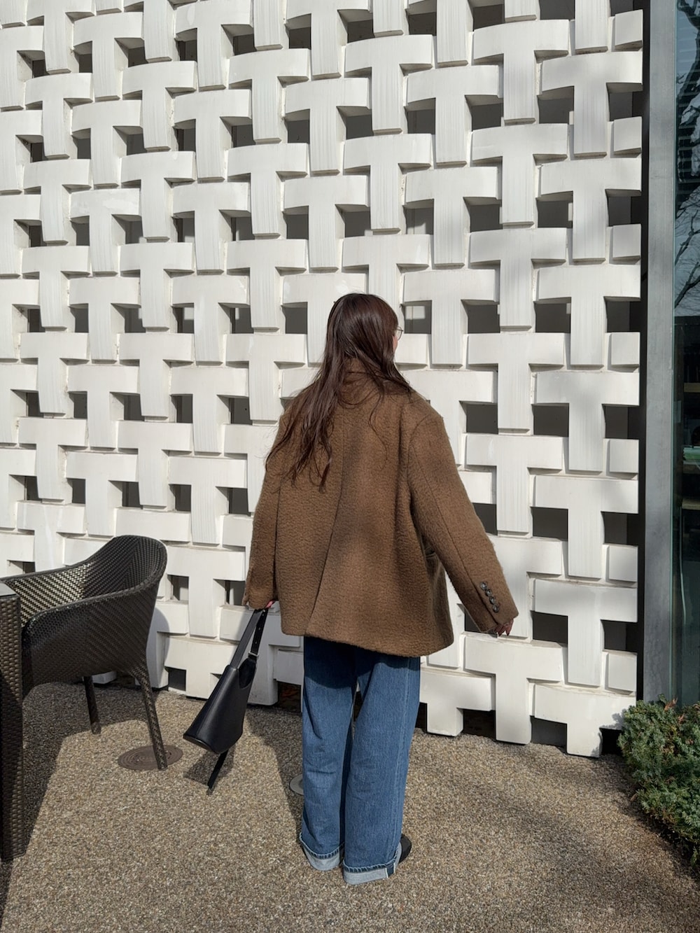 ブラウン系のその他アウター、ブルー系のデニムパンツ、ブラウン系のニット/セーターを着用したレディースの冬コーディネートの3枚目の写真