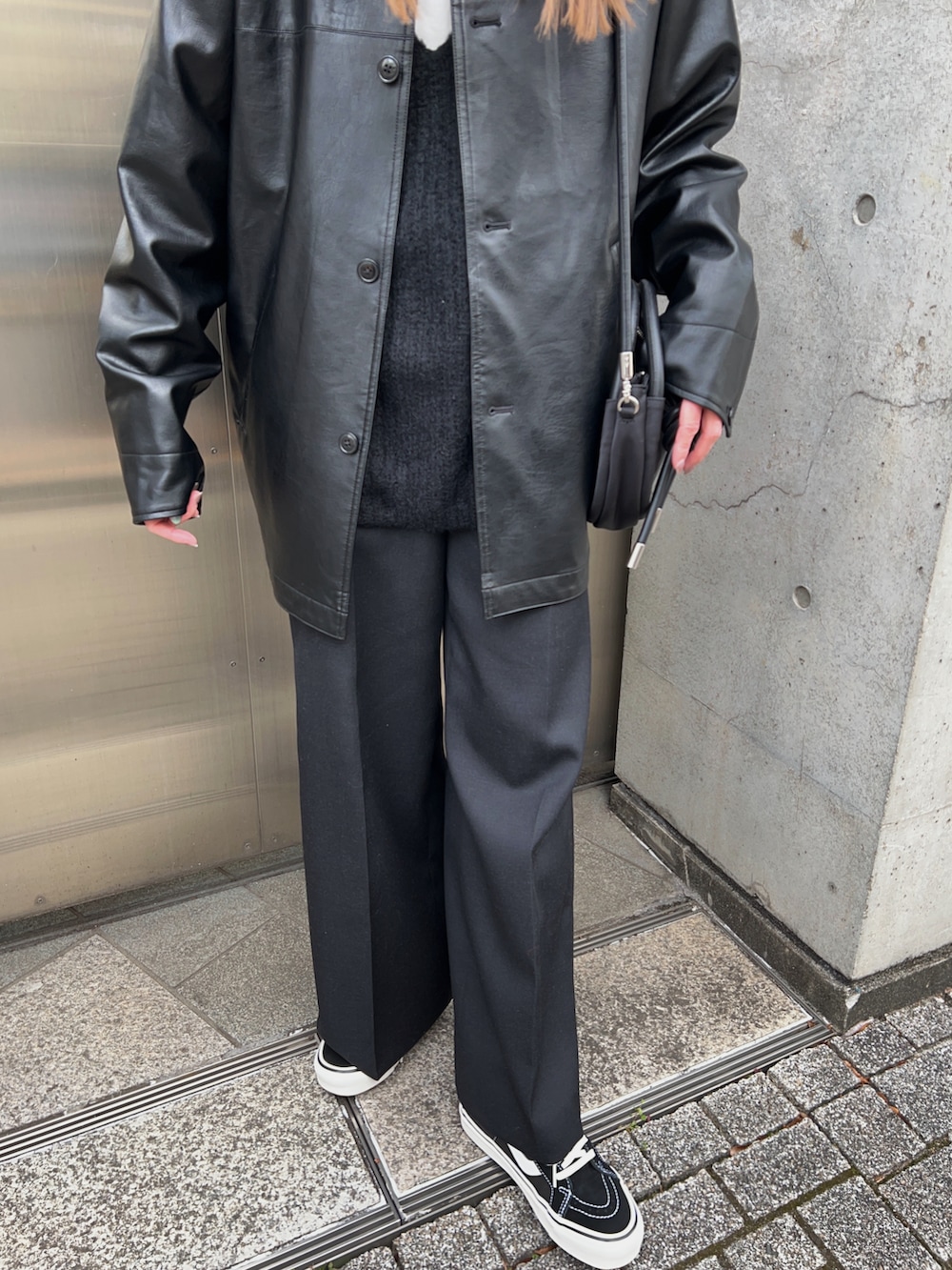 ブラック系のその他アウター、ホワイト系のTシャツ/カットソー、ブラック系のニット/セーターを着用したレディースの冬コーディネートの5枚目の写真