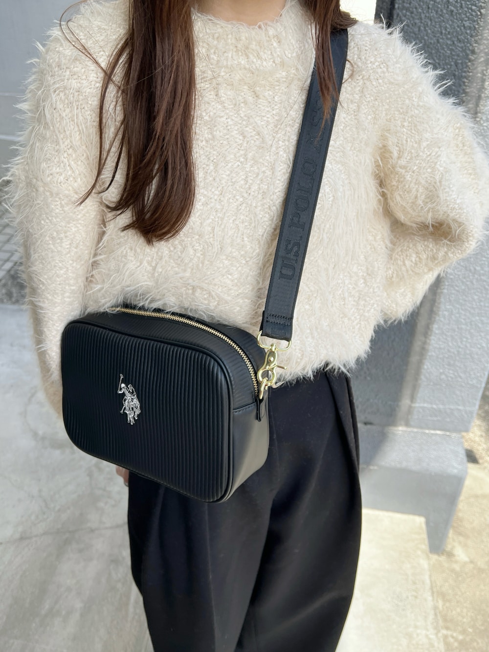 ホワイト系のニット/セーター、ブラック系のその他パンツ、ブラック系のショルダーバッグを着用したレディースの冬コーディネートの3枚目の写真