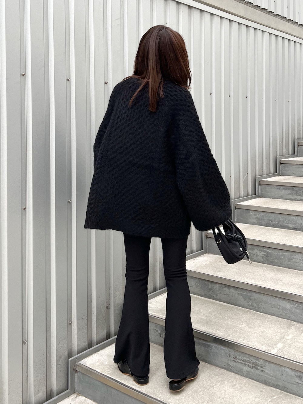 ブラック系のニット/セーター、ブラック系のショルダーバッグ、ブラック系のシューズを着用したレディースの秋コーディネートの3枚目の写真